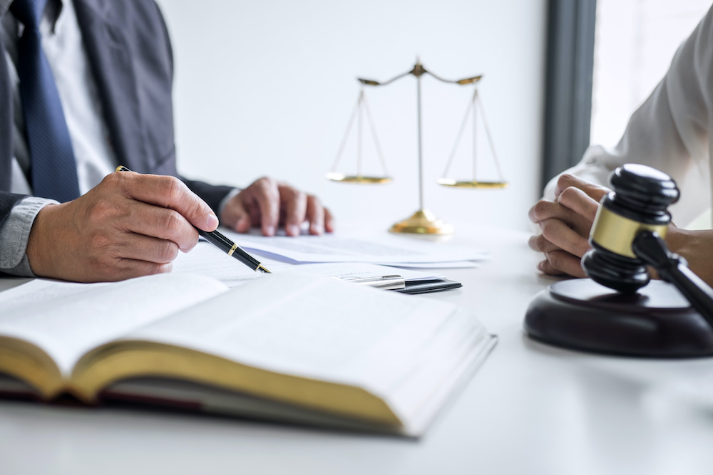 Anlita jurist vid upptäckt av dolda fel Consultation and conference of professional businesswoman and Male lawyers working and discussion having at law firm in office. Concepts of law, Judge gavel with scales of justice